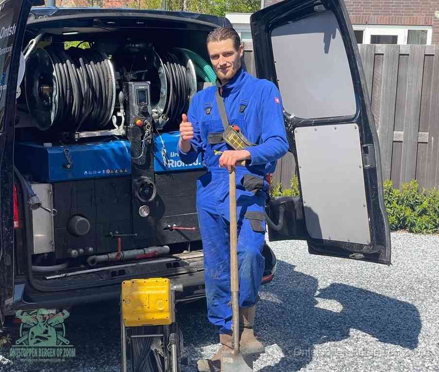 Een tevreden monteur met opgestoken duim naast de bestelbus, slim ingrijpen bespaart kosten bij een verstopte afvoer in Bergen op Zoom