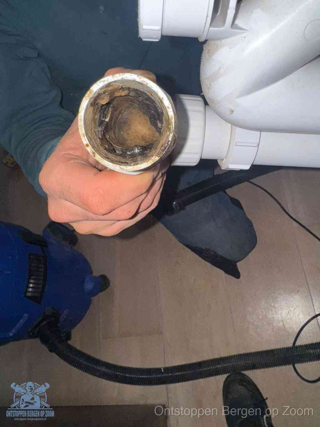 Een losgekoppeld afvoerbuisstuk dat van binnen volledig is dichtgeslibd, het gevolg van een verstopping te lang laten zitten in Bergen op Zoom