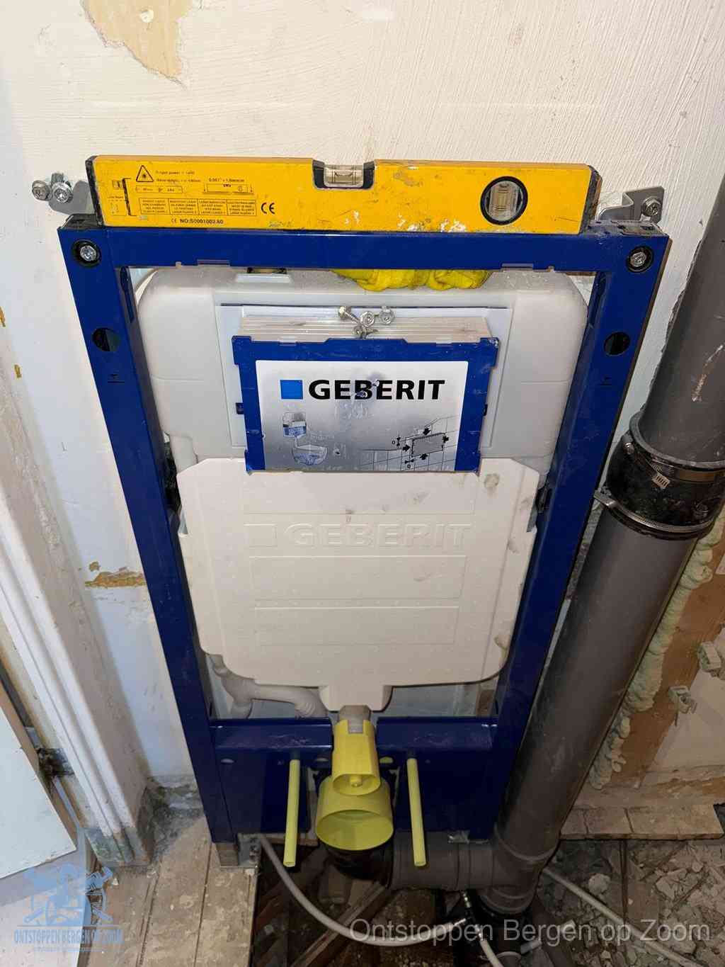 Een Geberit inbouwreservoir met frame voor een hangtoilet tegen de wand, met de afvoerbocht naar de vloer, kenmerkend voor een verstopt hangtoilet in Bergen op Zoom