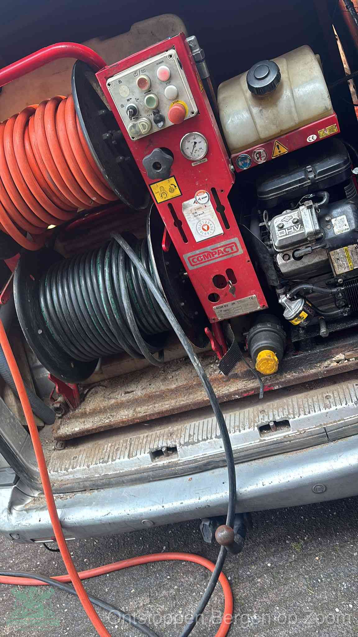 Een rood hogedruk-rioolreinigingstoestel in de laadbak van de bedrijfsbus, apparatuur voor een hardnekkige afvoerverstopping in Bergen op Zoom