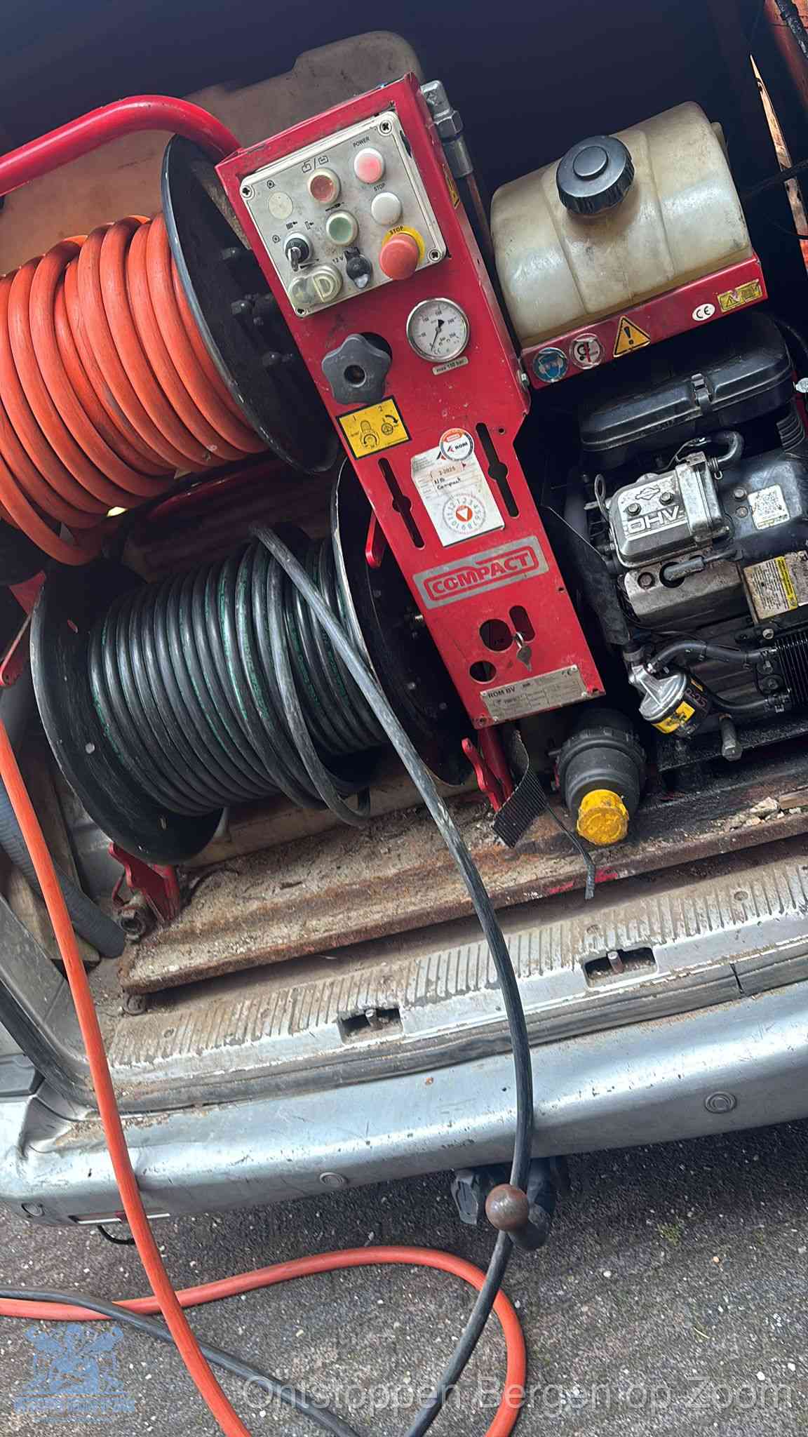 Een rood hogedruk-rioolreinigingstoestel met slangen in de laadbak van de bedrijfsbus, apparatuur voor een hardnekkige wc-verstopping in Bergen op Zoom