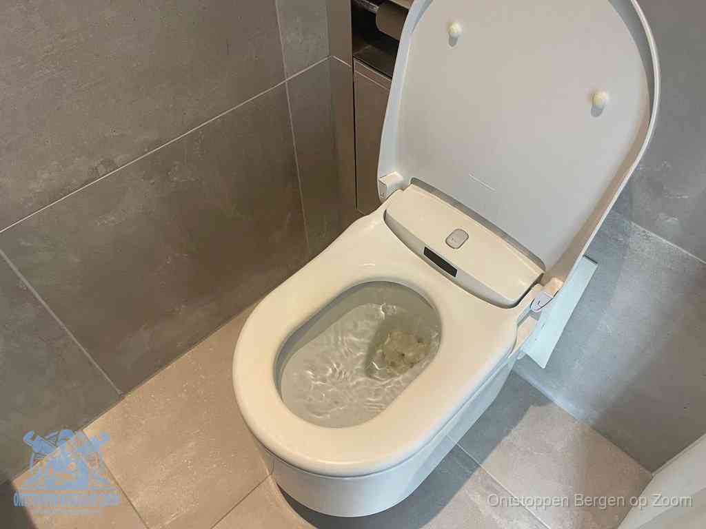 Een toiletpot vol troebel water met drijvend papier en restanten, de meest voorkomende oorzaak van een verstopte wc in Bergen op Zoom