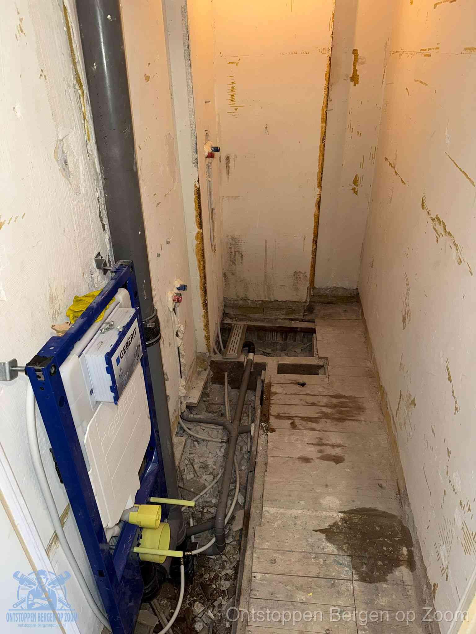 Een opgebroken toiletruimte tijdens renovatie met een Geberit inbouwreservoir en blootliggende oude afvoerleidingen, typisch voor oudere woningen in Bergen op Zoom
